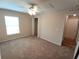Bedroom features a bright window, ceiling fan and adjacent doorway at 2555 Palmetto Ridge Cir, Apopka, FL 32712