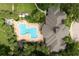 Aerial view of community pool, hot tub, and residence surrounded by mature trees at 2598 Robert Trent Jones Dr # 1030, Orlando, FL 32835