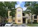 Inviting condo building with three stories, beige paint and black stairs, complemented by mature trees and ample parking at 2598 Robert Trent Jones Dr # 1030, Orlando, FL 32835