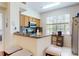 Kitchen with stainless steel appliances, wood cabinets, breakfast bar, and granite countertops at 2598 Robert Trent Jones Dr # 1030, Orlando, FL 32835