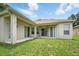 This backyard features a large lawn, a concrete patio, and sliding glass doors at 2674 Spicebush Loop, Apopka, FL 32712