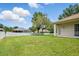 This backyard features a large lawn, a white vinyl fence, and mature trees at 2674 Spicebush Loop, Apopka, FL 32712