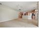 Spacious living room with ceiling fan, carpet floors and combined kitchen with dark appliances at 2674 Spicebush Loop, Apopka, FL 32712