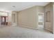 Open-concept living room with neutral carpet, neutral walls, and arched doorways at 2674 Spicebush Loop, Apopka, FL 32712