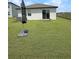 Grassy backyard featuring a sliding glass door entrance to the home at 2707 Virginia Pine Nw Dr, Bartow, FL 33830