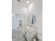 Bathroom featuring granite counters, white vanity, and stylish circular mirror at 2707 Virginia Pine Nw Dr, Bartow, FL 33830