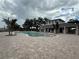 Community pool with an elegant white building, ample seating, and decorative palm trees at 2707 Virginia Pine Nw Dr, Bartow, FL 33830