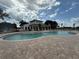 Community pool with blue water and a white building with large trees around at 2707 Virginia Pine Nw Dr, Bartow, FL 33830