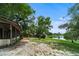Backyard showcasing mature trees, a lake view, and a patio area with ample space for outdoor activities at 2715 Wekiva Meadows Ct, Apopka, FL 32712