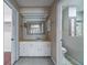 Well-lit bathroom vanity area with tile flooring, a decorative mirror, and access to the toilet and closet at 2715 Wekiva Meadows Ct, Apopka, FL 32712
