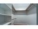 Empty walk-in closet with white shelves, wooden support bars, and wood-look flooring at 2715 Wekiva Meadows Ct, Apopka, FL 32712