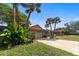 Well-maintained home with a two-car garage, palm trees, and a driveway leading to the entrance at 2715 Wekiva Meadows Ct, Apopka, FL 32712