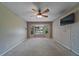 Neutral living room featuring a ceiling fan, a large bay window with natural light, and a wall-mounted TV at 2715 Wekiva Meadows Ct, Apopka, FL 32712
