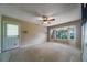 Neutral living room with a ceiling fan, bay window offering natural light, and outdoor access at 2715 Wekiva Meadows Ct, Apopka, FL 32712