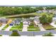 Aerial view of neighborhood homes with a pond, mature trees and green lawns at 3018 Bransbury Ct, Kissimmee, FL 34747