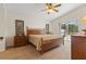 A primary bedroom with a wooden frame bed, carpet floors, and sliding glass doors to the lanai at 3018 Bransbury Ct, Kissimmee, FL 34747