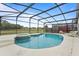 Screened-in pool area with a spa, lounge chairs, and views of the backyard at 3018 Bransbury Ct, Kissimmee, FL 34747