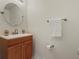 Traditional half-bath with a wood vanity, white countertop, oval mirror, and brushed nickel fixtures at 3018 Bransbury Ct, Kissimmee, FL 34747