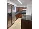 Kitchen featuring stainless steel appliances, dark cabinets, backsplash, and light tile flooring at 3057 Aaron Burr Ave # 2, Winter Park, FL 32792