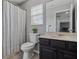 Bathroom featuring a vanity sink, toilet, shower/tub with a curtain, and a window view at 325 Green Ash Ln, Sanford, FL 32771