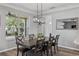 Elegant dining room with a modern light fixture and large windows overlooking the lush landscape at 325 Green Ash Ln, Sanford, FL 32771