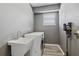 Functional laundry room with modern washer, dryer, utility sink, and wood-look flooring at 325 Green Ash Ln, Sanford, FL 32771