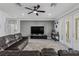 Inviting living room with a leather sectional sofa, ceiling fan, and modern entertainment center at 325 Green Ash Ln, Sanford, FL 32771