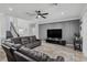Cozy living room featuring a large sofa, modern entertainment center, and staircase to the upper level at 325 Green Ash Ln, Sanford, FL 32771