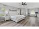 Bright main bedroom featuring wood floors, ceiling fan, and exercise area at 325 Green Ash Ln, Sanford, FL 32771