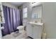 Bathroom featuring white vanity, mirror, and door, plus tile flooring, and shower with lavender curtain at 3822 Janie Ct, Orlando, FL 32822