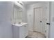 Bathroom featuring white vanity, mirror, and door, plus tile flooring, and an electric outlet at 3822 Janie Ct, Orlando, FL 32822