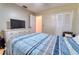 Bedroom with wood floors featuring a TV, closet, and full-sized bed at 3822 Janie Ct, Orlando, FL 32822