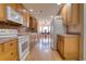 Functional kitchen with wood cabinets, white appliances, and access to dining area at 3822 Janie Ct, Orlando, FL 32822