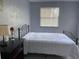 Bedroom featuring a black metal bed frame, accent table, and a large sunny window at 400 Palm Ave, Ormond Beach, FL 32174