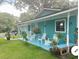 Inviting front porch with rocking chairs and colorful beach-themed decor and freshly cut lawn at 400 Palm Ave, Ormond Beach, FL 32174