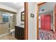 Bathroom featuring vanity with granite countertop, shower with glass doors, and colorful bedroom nearby at 4030 Cool Water Ct, Winter Park, FL 32792
