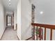 Hallway featuring a stone accent wall, carpet and wood railing and stairs at 4030 Cool Water Ct, Winter Park, FL 32792