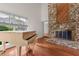 Open living room with wood floors, a fireplace, and a piano bathed in natural light at 4030 Cool Water Ct, Winter Park, FL 32792