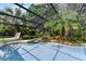 View of backyard screened in pool area with tropical landscaping and lounging chairs at 4030 Cool Water Ct, Winter Park, FL 32792