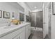 Bright bathroom featuring double vanity, quartz countertop, and glass-enclosed shower with stylish gray tiling at 490 Belmond Dr, Debary, FL 32713
