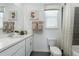 Well-lit bathroom with a clean white vanity, decorative mirror, and combined shower and tub at 490 Belmond Dr, Debary, FL 32713