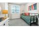 Bright bedroom featuring a comfy twin bed, light gray carpet, and lively colorful art pieces at 490 Belmond Dr, Debary, FL 32713