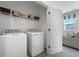 Bright laundry room with washer, dryer, and overhead storage shelves at 490 Belmond Dr, Debary, FL 32713