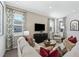 Cozy living room showcasing a plush sofa, media console, and an abundance of natural light through multiple windows at 490 Belmond Dr, Debary, FL 32713