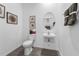 Elegant powder room featuring a pedestal sink, decorative mirror, and stylish wall art at 490 Belmond Dr, Debary, FL 32713