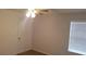A simple bedroom, with neutral walls and carpet, features a ceiling fan and window at 5160 Conroy Rd # 1437, Orlando, FL 32811