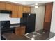 Functional kitchen with wood cabinets, black appliances, and a convenient breakfast bar for casual dining at 5160 Conroy Rd # 1437, Orlando, FL 32811