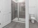 Bathroom featuring glass-enclosed shower, gray tile, and a toilet at 558 Orient Ave, Debary, FL 32713