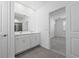 Bright bathroom with dual sinks, white cabinets, and doorway to bedroom at 558 Orient Ave, Debary, FL 32713