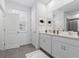 Bright bathroom features a double sink vanity, a large mirror, white cabinets and a shower with glass door at 558 Orient Ave, Debary, FL 32713